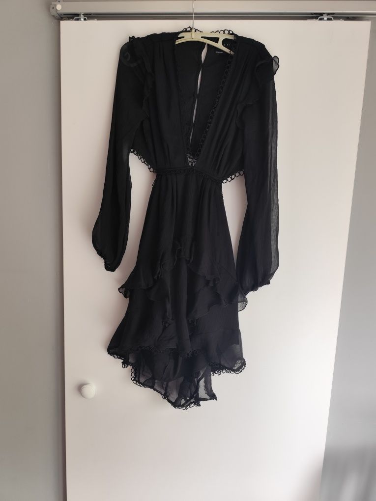 Elegancka czarna asymetryczna mini sukienka z głębokim dekoltem i wyci