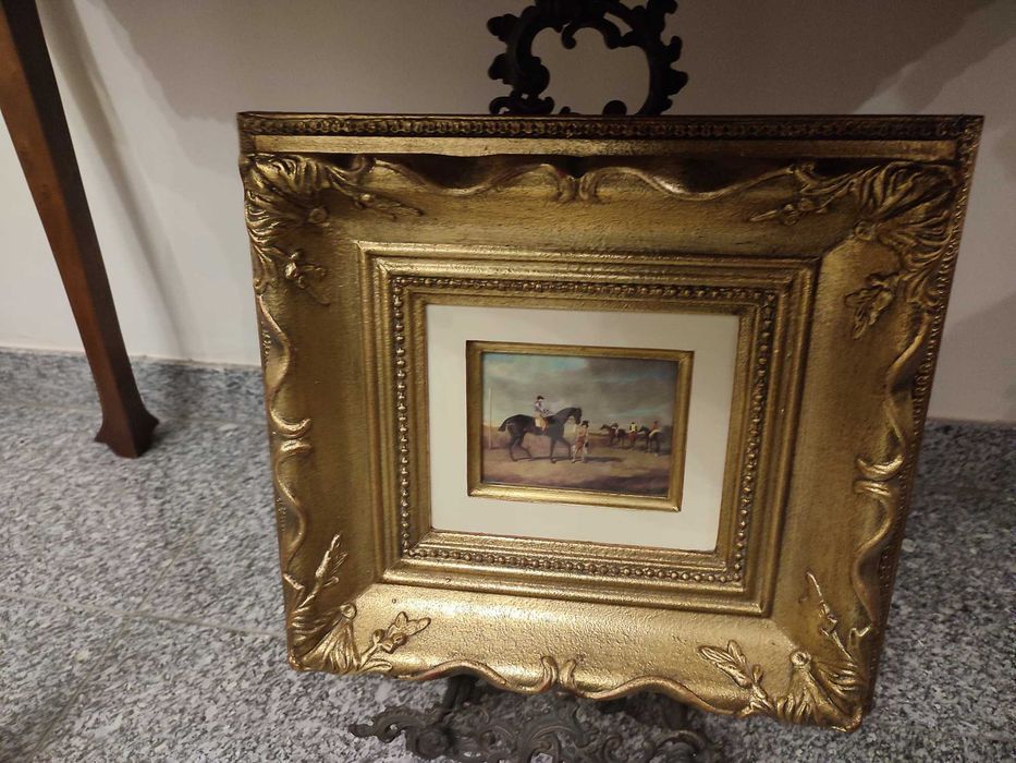 Quadro moldura em folha de ouro e gravura de cavalos. Vista ouro.