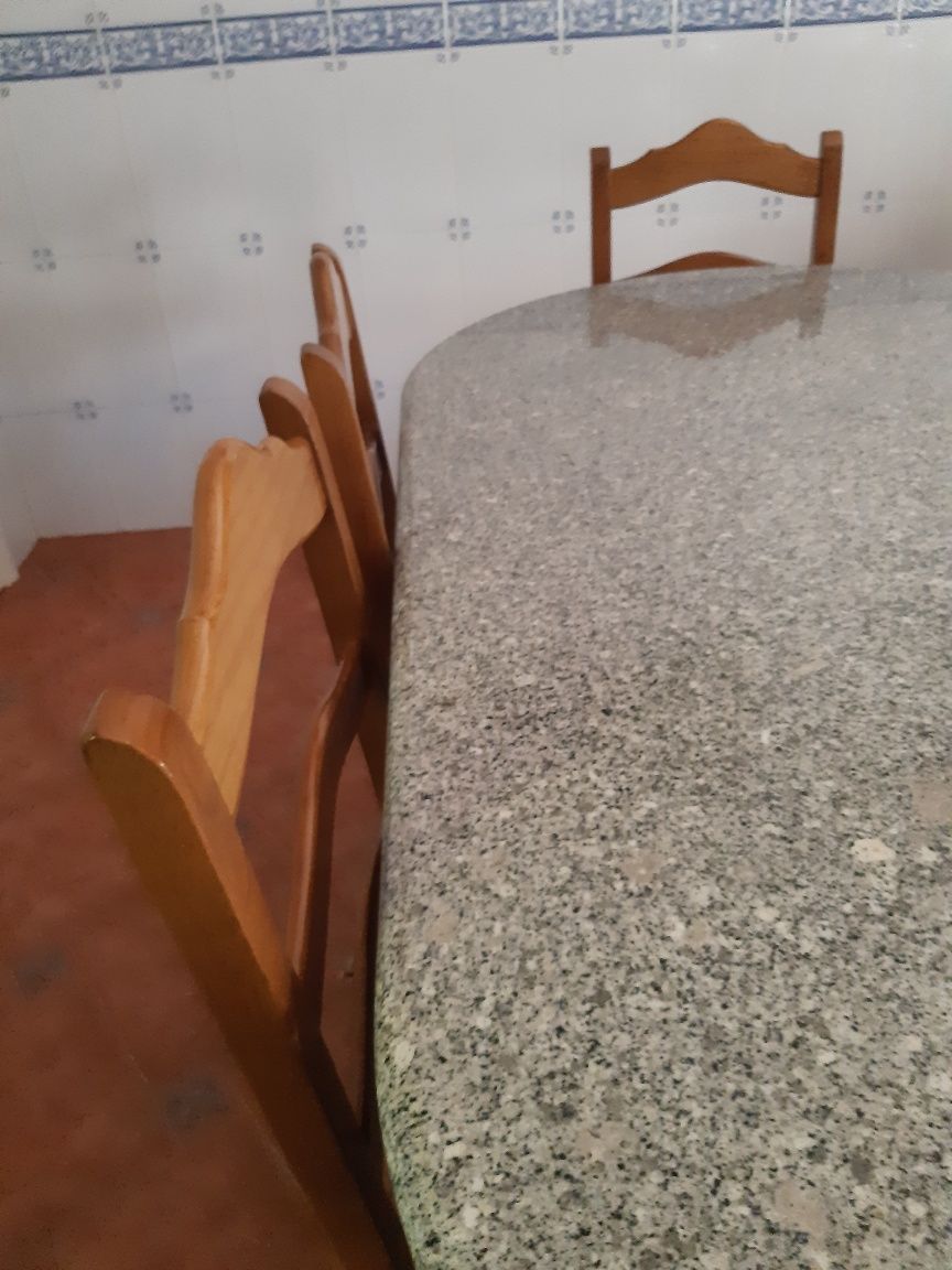 Mesa de pedra com 6 cadeiras.