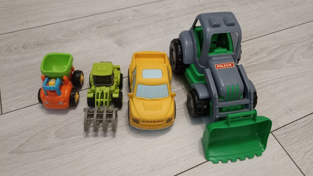 Zestaw czterech plastikowych pojazdów, auta i traktory