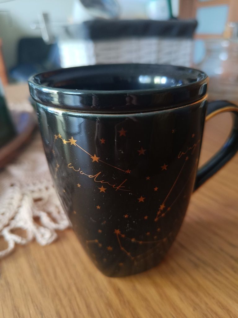 Kubek czarny że złotym znak zodiaku