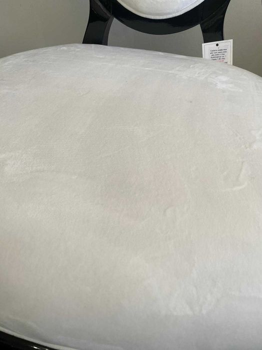 Cadeira elegante em veludo branco com estrutura preta de exposição