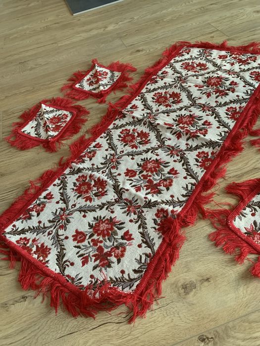 Czerwony bieżnik i podkładki z frędzelkami, jest cały wyszywany