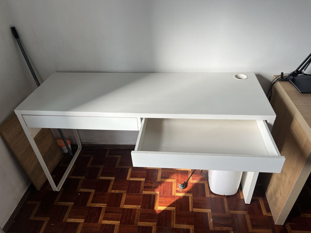 Mesa de escritorio branca com duas gavetas e entrada para fios.