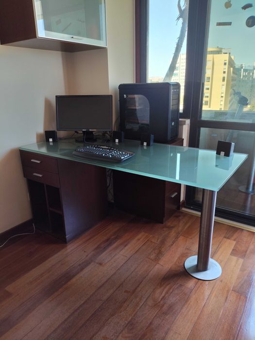 Secretária de vidro com gavetas em madeira.