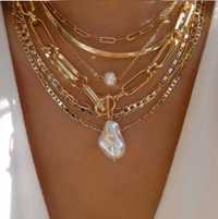Разные ожерелья золотого цвета с цепями и жемчугом.