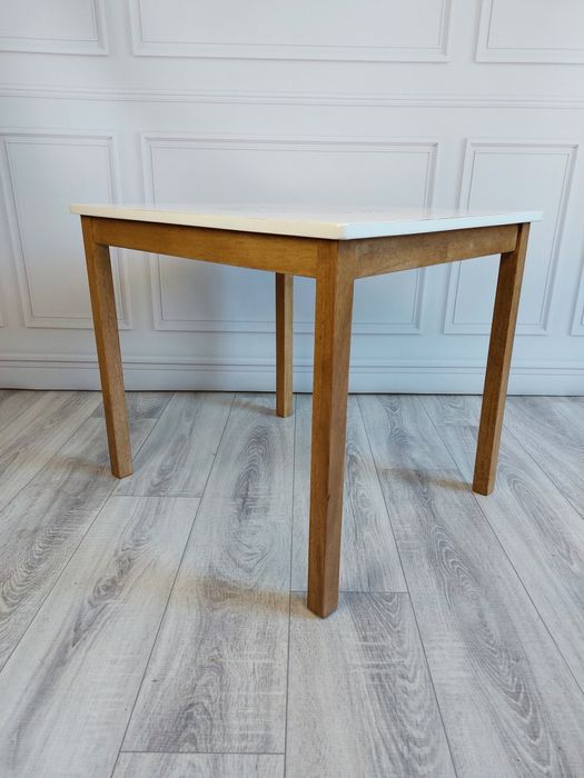 Biały stolik kawowy z drewnianymi nogami