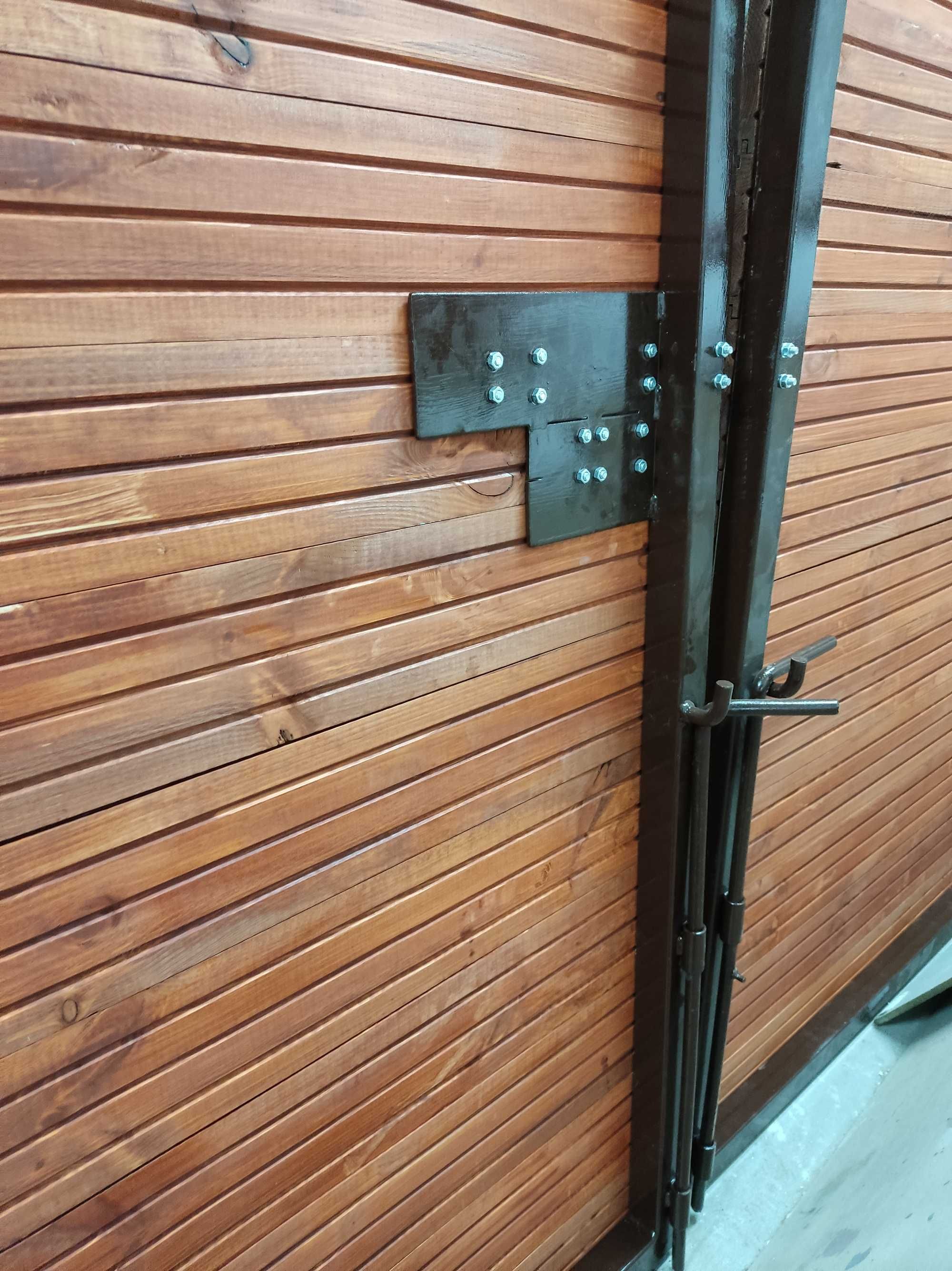 Drewniana brama wjazdowa do garażu na solidnej konstrukcji stalowej.