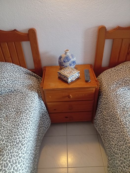 Duas camas de solteiro com uma mesa cabeceira