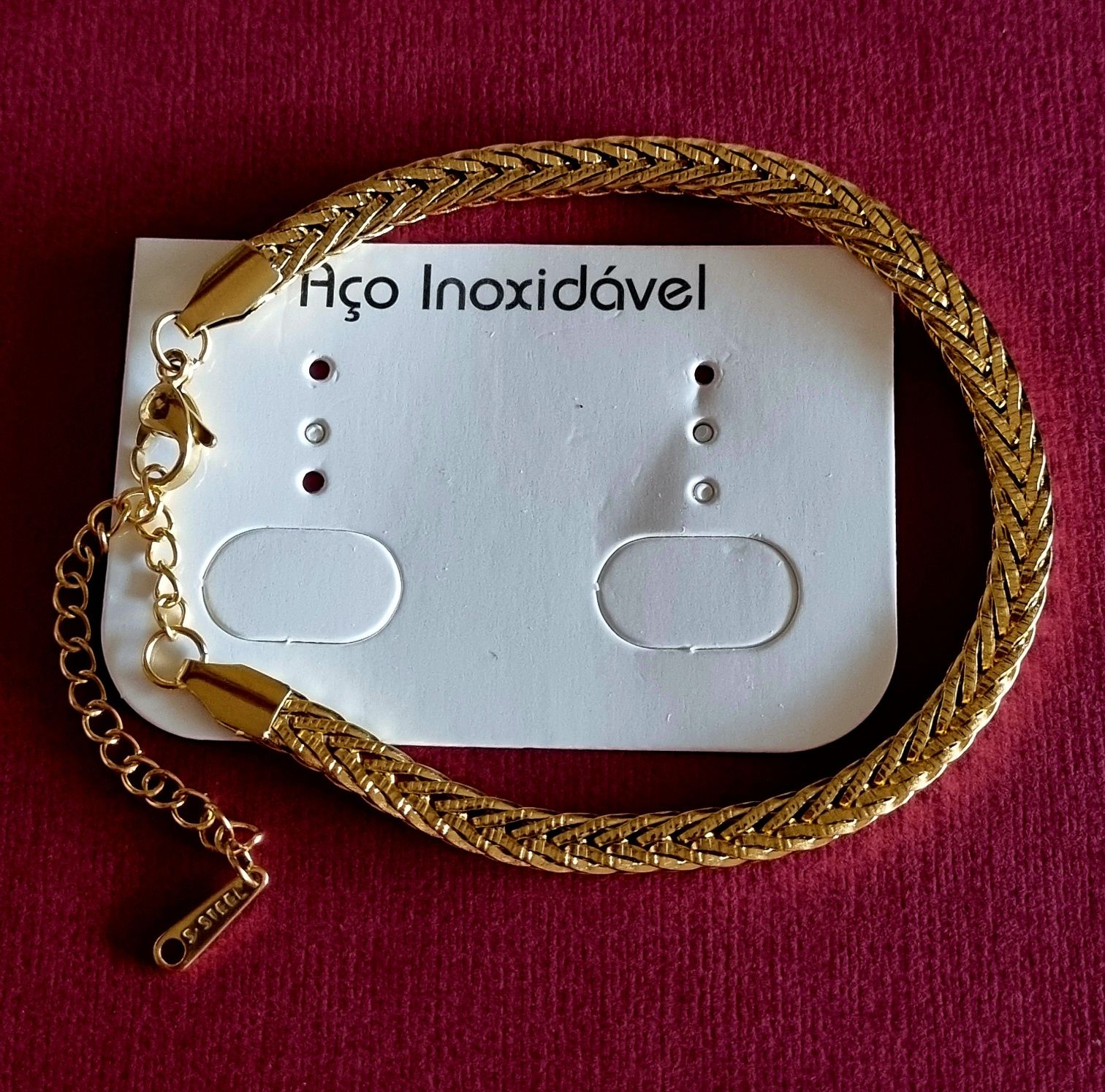 Pulseira dourada, em aço inoxidável. Tem extensor