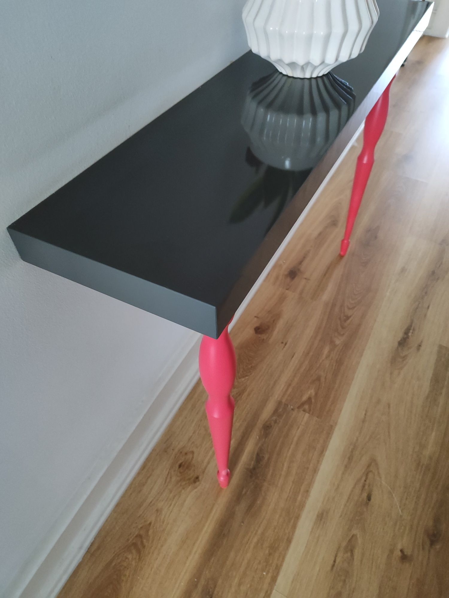 Consola IKEA. Prateleira cinza e pernas rosa.