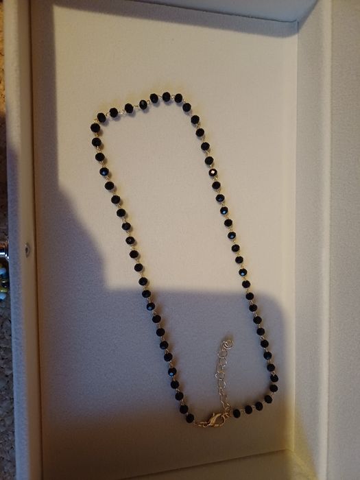 Colar dourado com contas pretas. Novo.