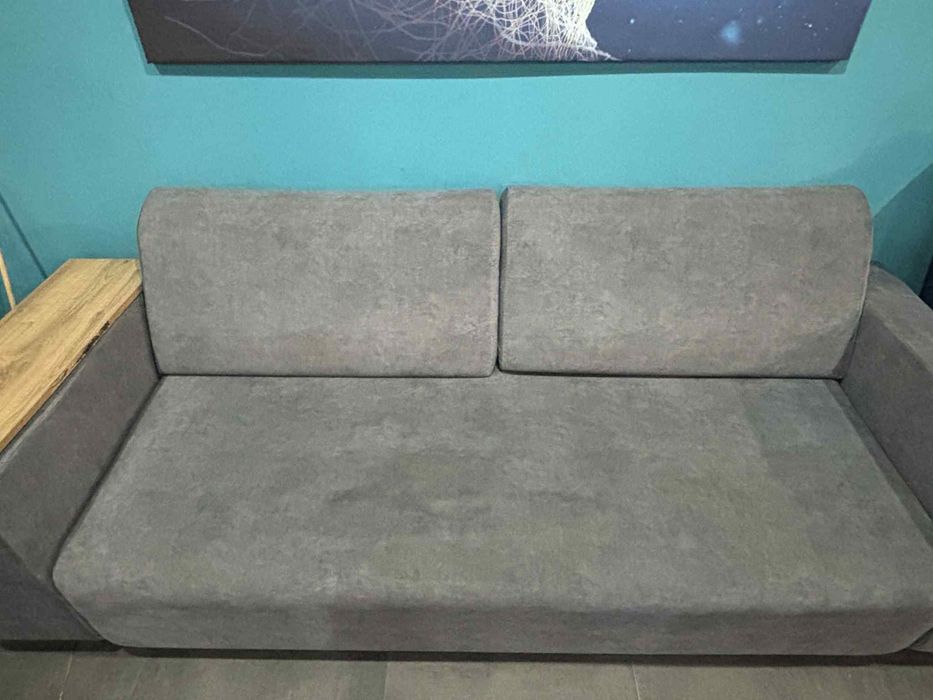 Sofa z pufą półkami i funkcją spania
