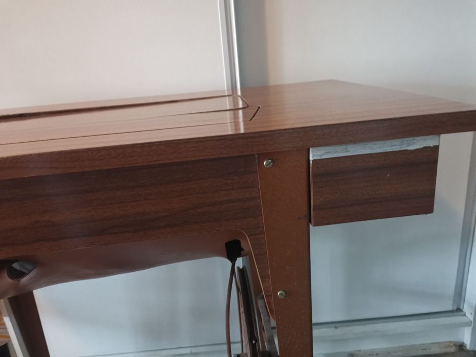 Máquina de costura a trabalhar com móvel com gavetas