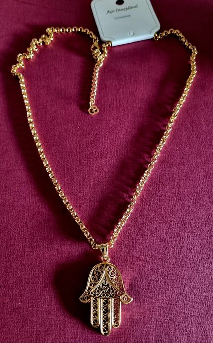 Colar comprido dourado, em aço, com a mão de Fátima em filigrana..