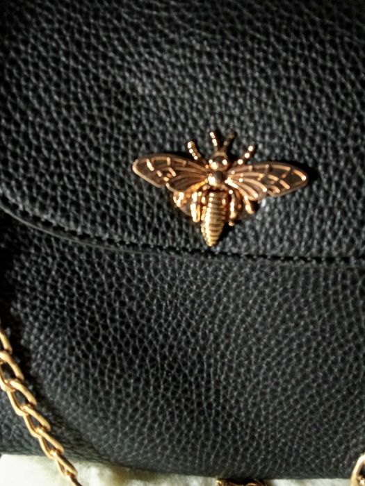 Bolsa feminina pequena com detalhe mariposa dourado