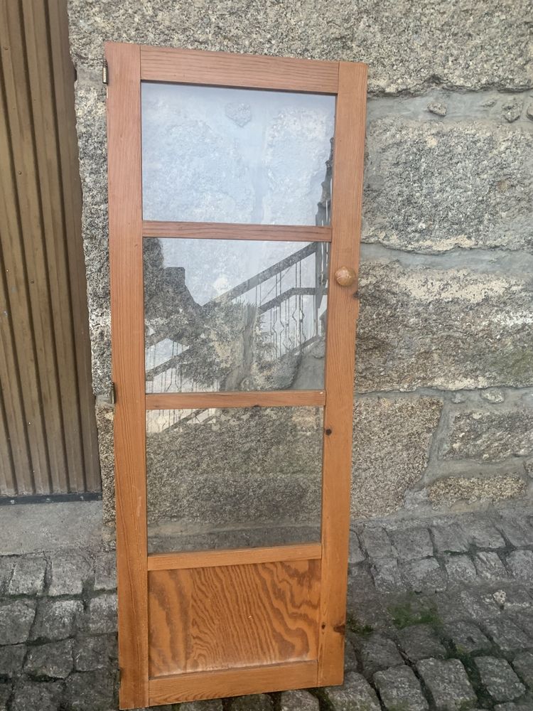 Porta de armário de madeira com puxador e trancas, janelas de vidro