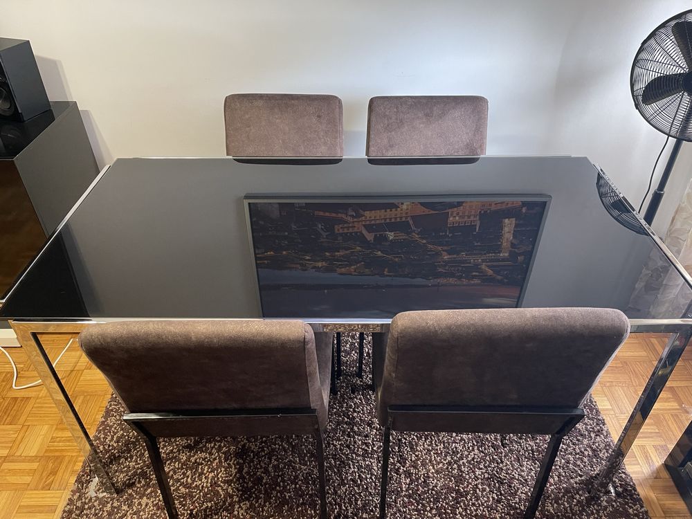 Mesa de sala com caddiras .