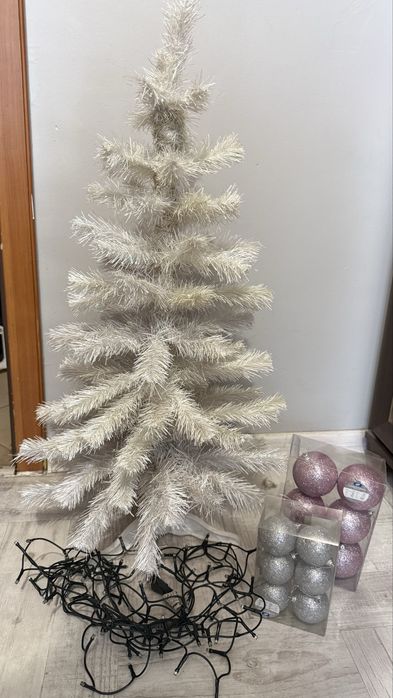 Biała sztuczna choinka z bombkami i lampkami