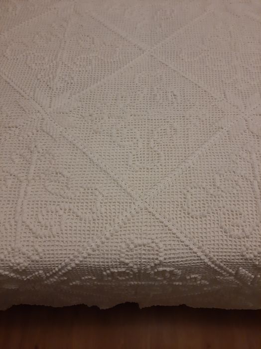 Colcha branca de renda feita à  mão .