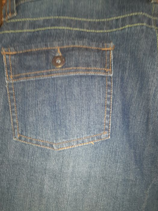 Calça de ganga por cima do tornozelo