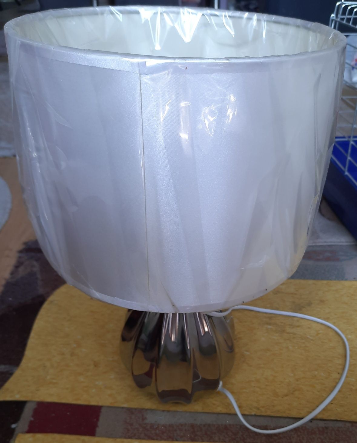 Lampa z ozdobnym abażurem i srebrną podstawą