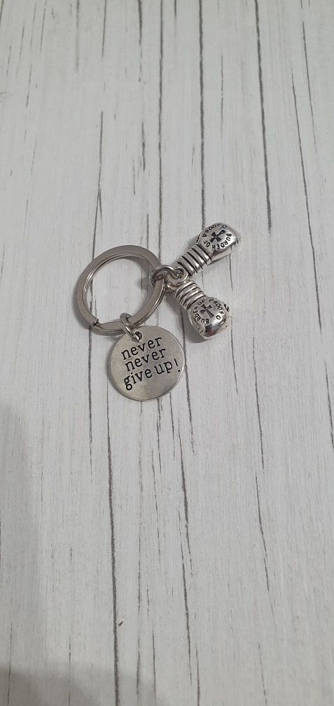 Srebrny bryloczek do kluczy w kształcie rękawic bokserskich.