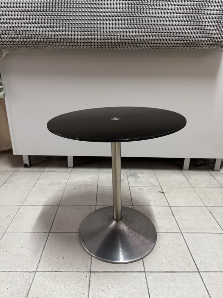 Mesa de apoio com tampo de vidro preto.