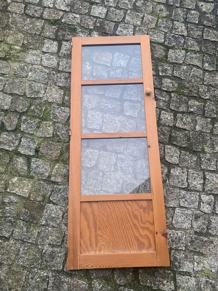 Porta de armário de madeira com puxador e trancas, janelas de vidro