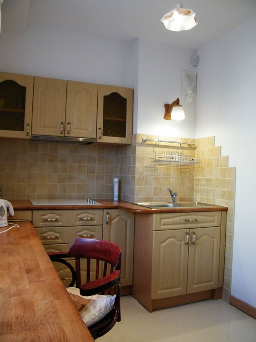 Kuchnia na wymiar z drewnianym blatem i okapem