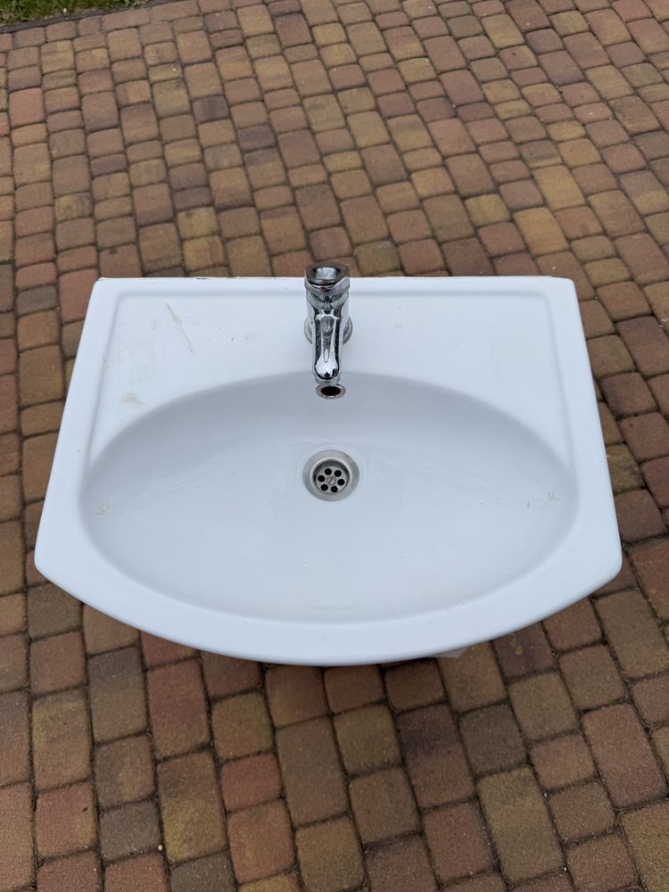 Szafkal łazienkowa z umywalką i baterią.