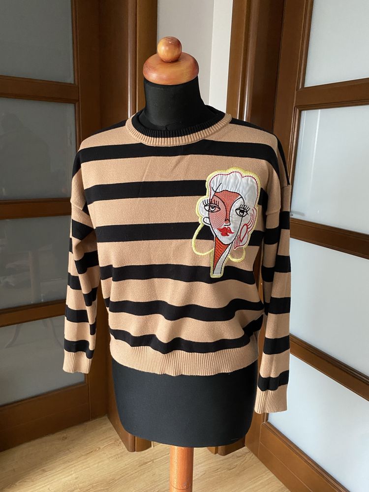 Damski gruby sweter w paski z naszywką