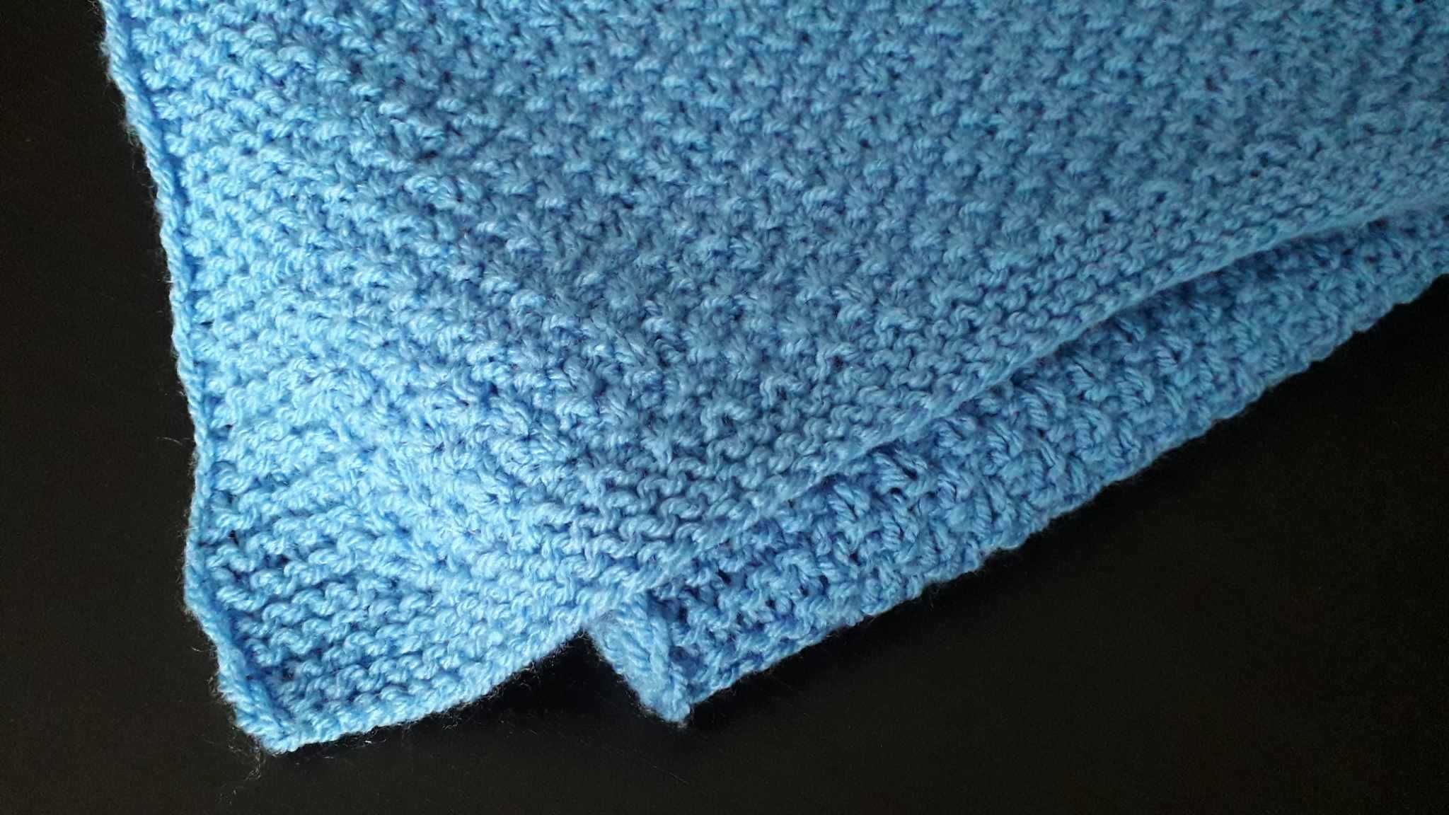 Niebieski kocyk dla niemowlaka robiony na drutach