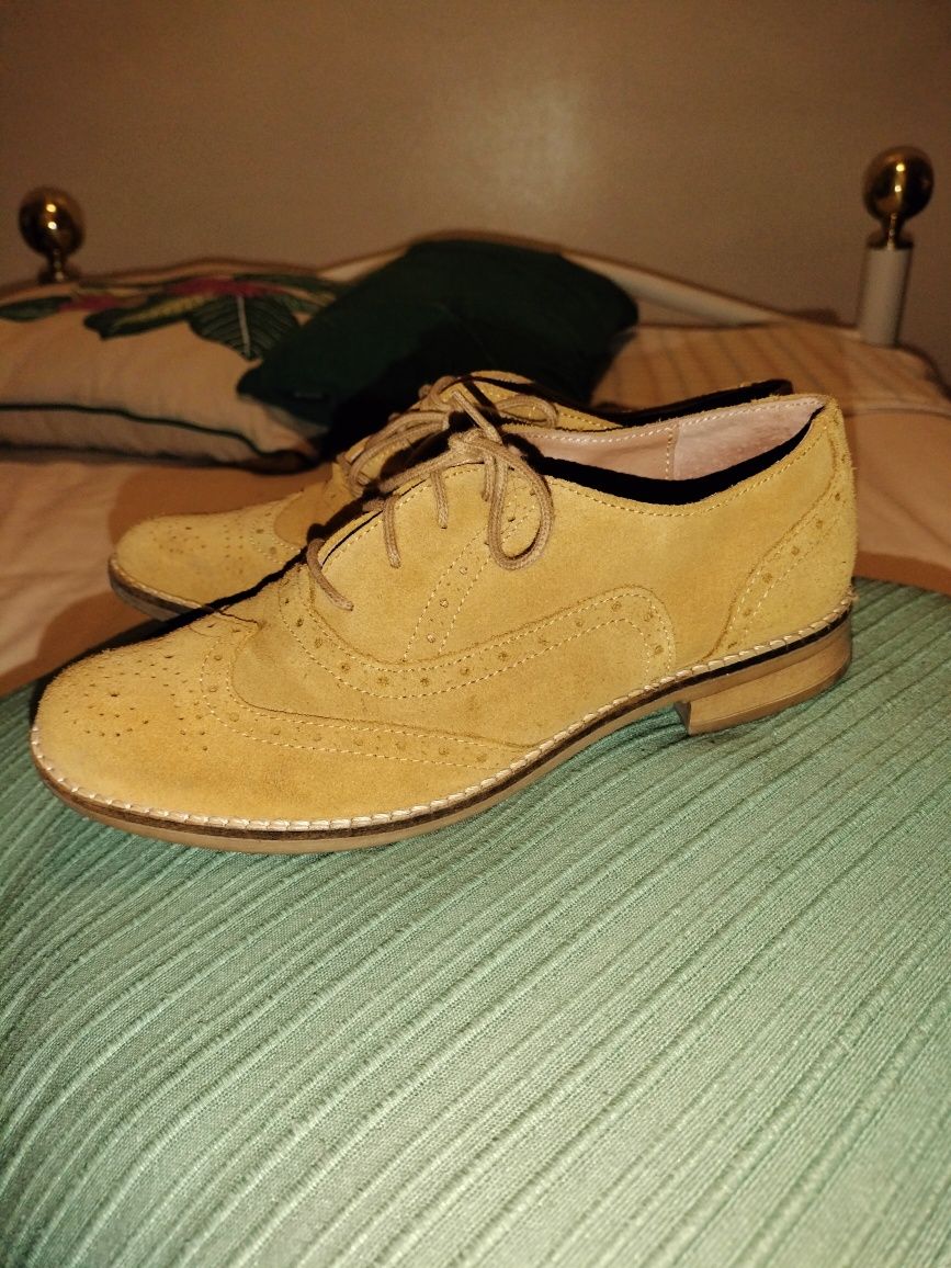 Sapatos com biqueira rdonda com atacadores em tecido tipo camurça.