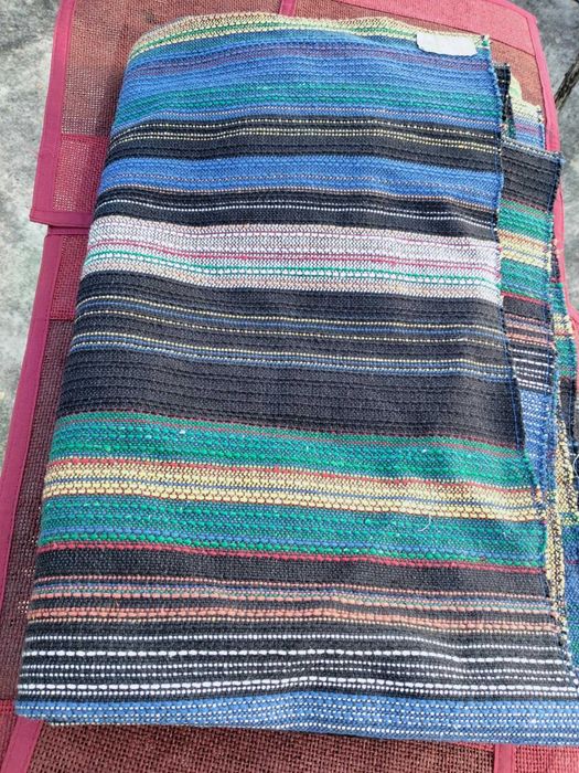 Carpete ás riscas com tons de azul e verde vivo, coberta ou manta.