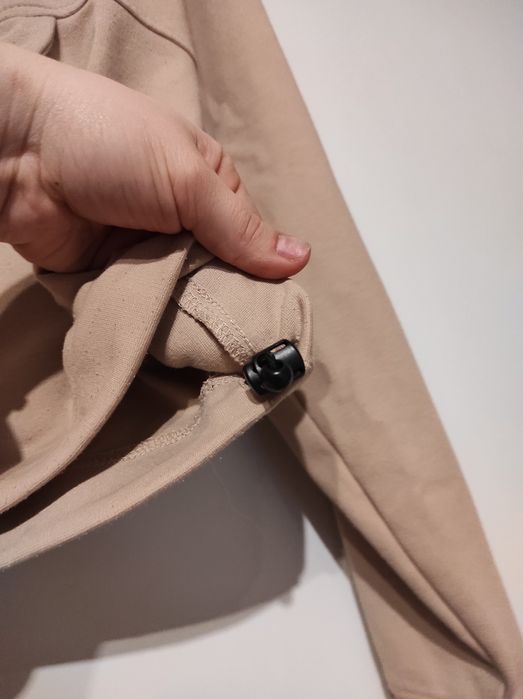 Beżowa bluza z kieszenią i ściągaczem w pasie