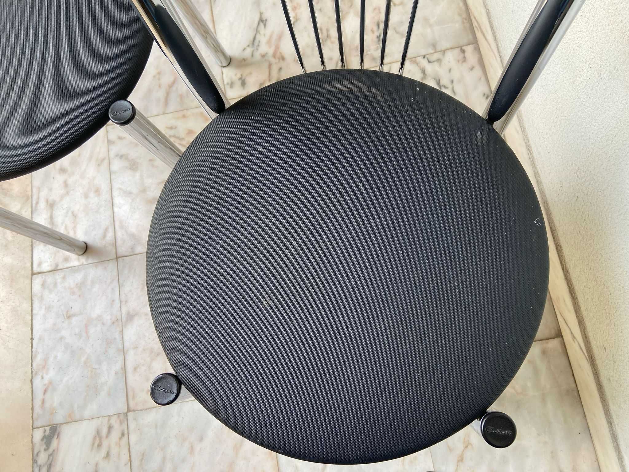 Duas cadeiras de metal, com tampo preto