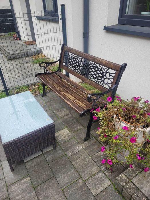 Ławka drewniana z rzeźbionym oparciem.