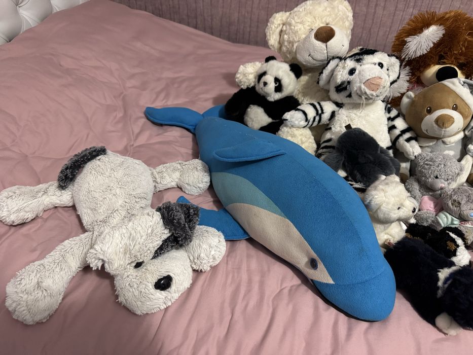 Багато різних дитячих мʼяких іграшок дельфін ведмідь собака панда тигр