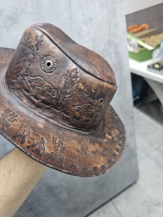 Skórzany australijski kapelusz bogato zdobiony.