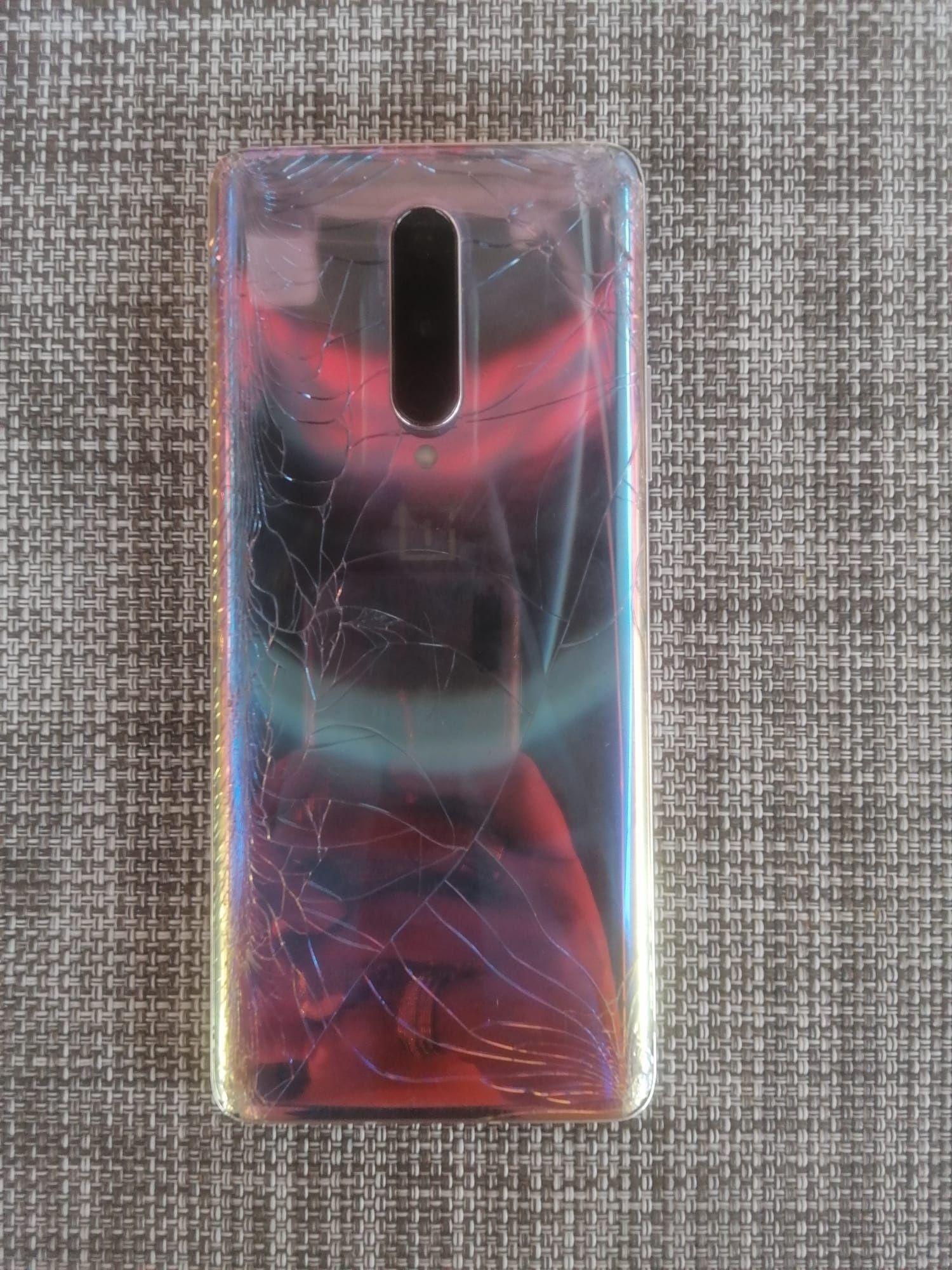 OnePlus 8 com parte traseira estilhaçada e botão on sensível