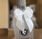Białe kokardki na alkohol weselny