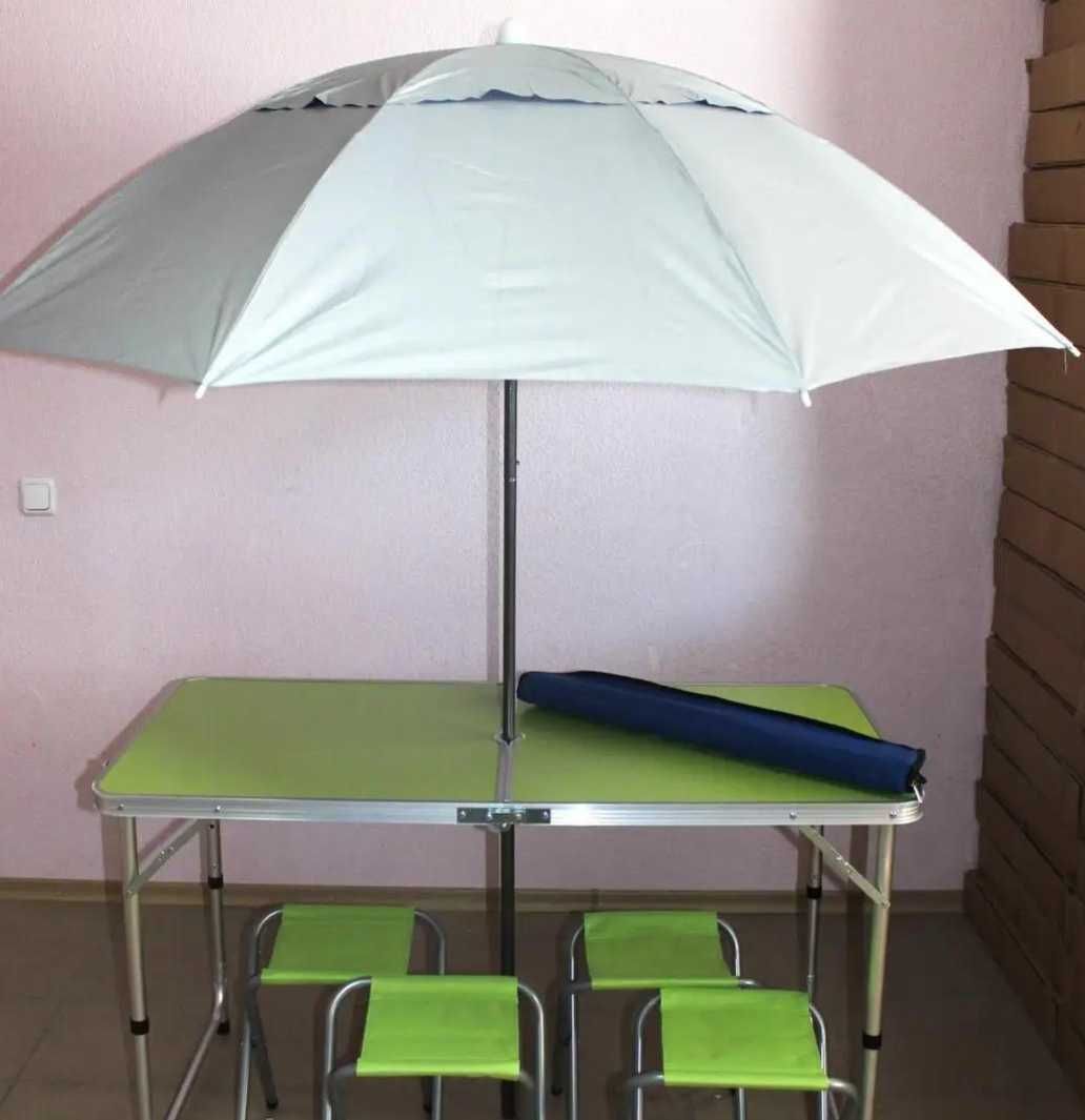 Розкладний стіл зі стільцями та парасолькою.