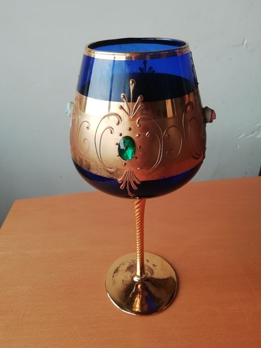 Copo de coquetel com flores e jóias.