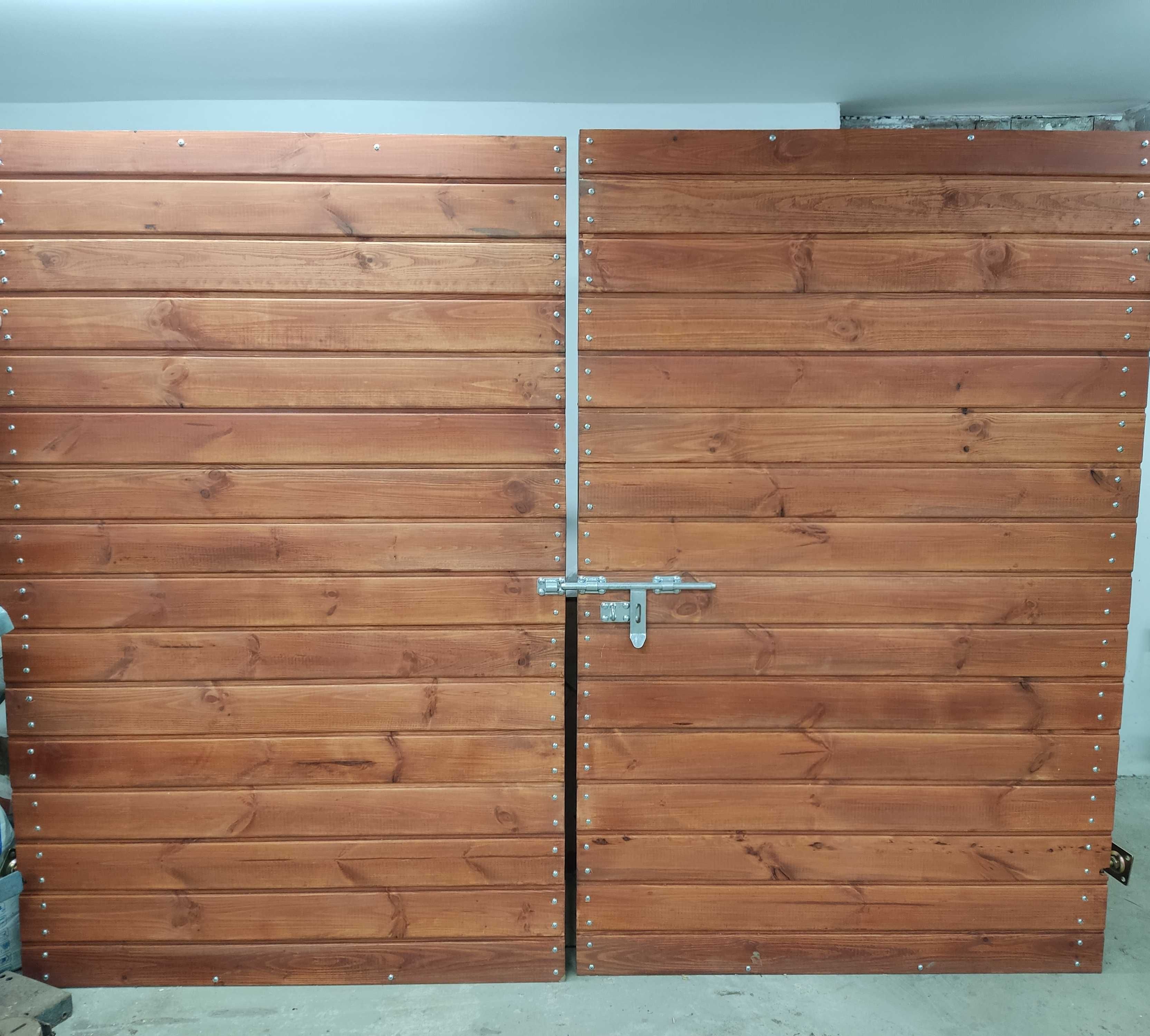 Drewniana brama wjazdowa do garażu na solidnej konstrukcji stalowej.