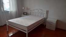 Cama casal e mesas de cabeceira