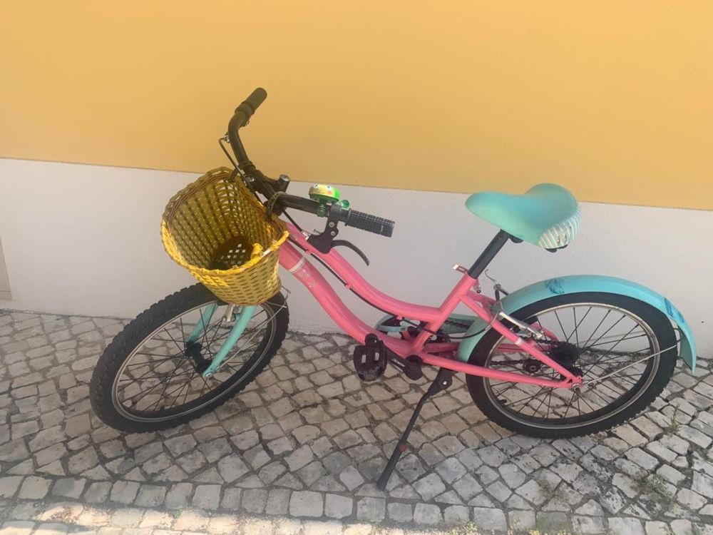 Bicicleta menina rosa e verde com cestinha.