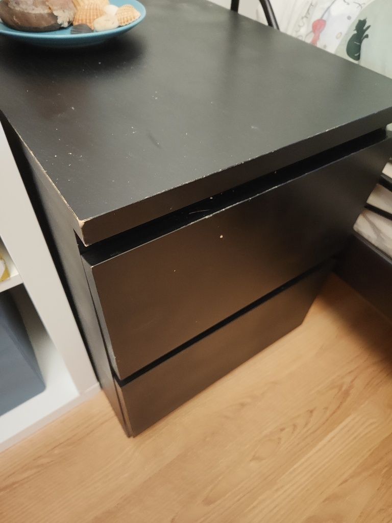 Cama de ferro preta com colchões e mesa de cabeceira