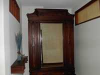 Armário antigo. De madeira e com um espelho como porta
