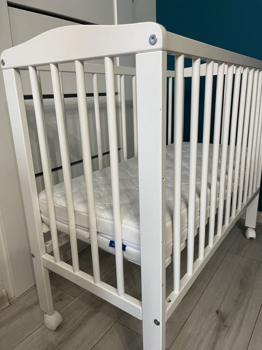 Małe łóżeczko dziecięce niemowlęce drewniane na kółkach z materacem